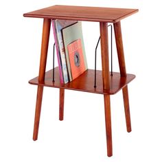 a small wooden table with books on it and a magazine rack in the bottom corner