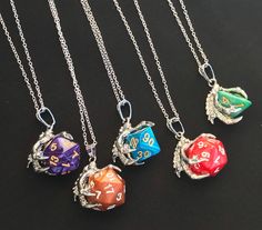 Handmade Dungeons and Dragons inspired necklace! Make a great accessory for your next D&D game, or for everyday wear!  The necklace is customizable, you can select the dice color, and which dice (D20, D12, D10, D8, D6, D4) you would like! See listing images for the dice colors available.  The dice is glued to the claw pendant to prevent it from falling out.  Materials:  - dice  - platinum plated alloy claw pendant  - super glue - silver colored chain  - silver colored lobster claw clasp - silver Dice Cage Necklace Diy, Enby Style, Caged Necklace, Dragon Dies, Dungeons And Dragons Dice, Dragon Bracelet, Dragon Jewelry, Inspired Necklace, The Claw