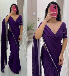 a woman in a purple sari taking a selfie