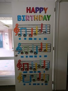 a door decorated with musical notes and the words happy birthday written on it in multicolored letters