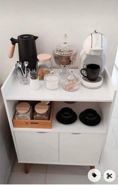 a white counter topped with lots of different types of coffee machines and cups on top of it