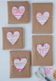 four brown boxes with hearts on them tied to twine and some other crafting supplies