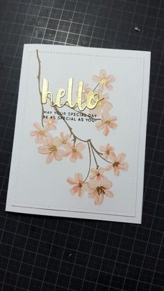 a card with the word hello written on it and some flowers in front of it