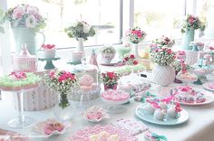 a table topped with lots of cakes and desserts