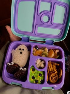 a purple and blue lunch box with food in it's compartment, including pretzels