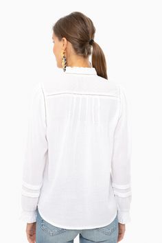 Embrace casual bohemian vibes in this peasant style blouse. Featuring romantic blouson sleeves and delicate embroidery along on the neckline and chest, this relaxed and graceful top exudes laid back femininity.

Ladder Trim
Picot Ruffle Sleeves & Neck
Clip Dot Cuffs
Pearl Buttons
100% Cotton
Care: Machine wash cold, lay flat to dry Flowy Long Sleeve Tops With A Free-spirited Style, Casual White Blouse With Boho Collar, Casual Peasant Top With Flowy Lantern Sleeves, Free-spirited Long Sleeve Vacation Tops, Casual Flowy Lantern Sleeve Peasant Top, Casual Flowy Peasant Top With Lantern Sleeves, Long Sleeve Boho Top For Vacation, Casual Blouse With Boho Collar For Spring, Relaxed Fit Long Sleeve Peasant Top For Vacation