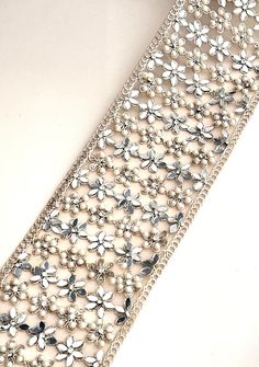 >>Gold Pearl Mirror Embellished Border Flower Pattern Sari Trim  >>8cm Tulle Fabric for Wedding Costume dresses Wedding Sash Belts & Upholstery >> Width -8cm  >> Color-  light gold  >> Material - Tulle , Pearl ,Mirror Perfect for bridal lehengas, sarees, and dupattas, this trim is also a beautiful addition to sash belts, home décor, and upholstered furniture. PLEASE FOLLOW US ON THE FOLLOWING LINKS FOR NEW LAUNCHES 𝐖𝐞𝐛𝐬𝐢𝐭𝐞: www.lacetrimssindia.com 𝐈𝐧𝐬𝐭𝐚𝐠𝐫𝐚𝐦: @lacetrimssindia 𝐏𝐢 Elegant Lace Bridal Belt For Party, Silver Bridal Belt With Pearl Embroidery, Silver Bridal Belt With Pearl Embroidery For Wedding, Silver Embellished Lace For Party, Silver Lace With Lace Work For Party, Elegant Embellished Trims For Wedding, Silver Embellished Sash For Party, Silver Embellished Party Sashes, Silver Embellished Sashes For Party