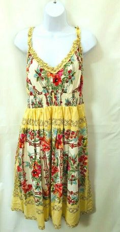 a white mannequin wearing a yellow floral dress