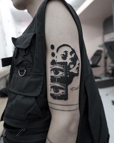 a man with a tattoo on his arm has a black and white image of a woman's face