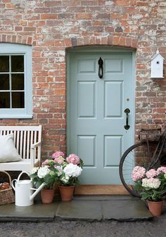 an image of a front door with flowers in pots