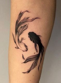 a woman's leg with a black and white koi fish tattoo on it