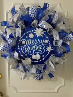 a blue and silver christmas wreath hanging on the front door