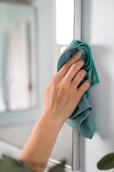 a person wiping up the wall with a microfil towel and cloth on it