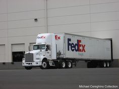 a fedex truck is parked in front of a building with an ex logo on it