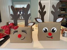 two brown bags with reindeer faces on them sitting on a counter next to each other