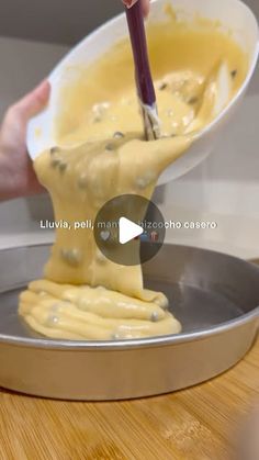 someone is mixing batter in a pan with a spatula to make something yellow and brown