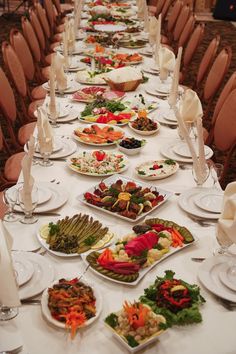 a long table covered with plates and bowls filled with food