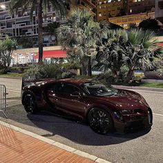 a bugatti car parked on the side of the road in front of palm trees