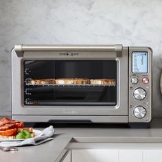 a toaster oven sitting on top of a counter next to a plate with food