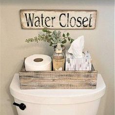 a toilet with a wooden sign above it that says water closet