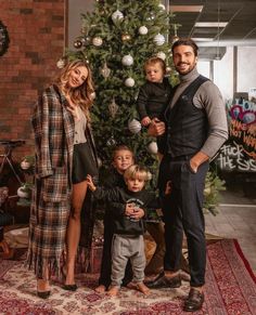 a family standing in front of a christmas tree