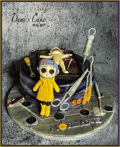 a cake that has been decorated to look like a doll with scissors and other items