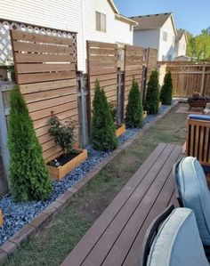 a backyard area with wooden fence and blue stones on the ground, surrounded by wood planters