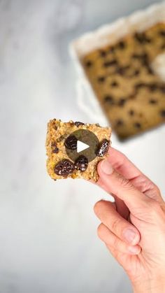 someone is holding up a cookie with chocolate chip cookies in the shape of an oatmeal