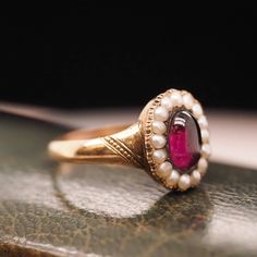 Year: 1863 (Engraved on inner shank) Item Details: Ring Size: 7 Metal Type: 9k Yellow-Rose Tone Gold [Hallmarked, and Tested] Weight: 3.0 grams Center Details: Tourmaline, Deep Purple, 7.7mm x 5.25mm, Natural Side Stone Details: Seed Pearls, 2mm each. Band Width: 2.55mm Condition: Excellent Victorian Payment & Refund Details: More Pictures Available on Request Payment via Visa/Mastercard/Discover/AmericanExpress, check, money order or PayPal. Layaway * We will be more than happy to provide layaw Cabochon Ruby Ring For Wedding, Fine Jewelry Cabochon Signet Ring For Wedding, Fine Jewelry Signet Ring With Cabochon For Wedding, Fine Jewelry Wedding Signet Ring With Cabochon, Victorian Ruby Cluster Ring For Wedding, Antique Gemstone Signet Ring For Wedding, Antique Cabochon Emerald Wedding Ring, Heirloom Cabochon Emerald Ring For Wedding, Heirloom Cabochon Emerald Wedding Ring