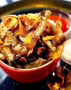 a red bowl filled with fried potato chips