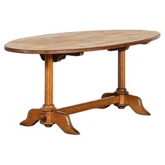 an oval wooden table with two leaves on the top and one leaf at the base