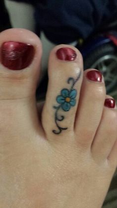 a woman's foot with a flower tattoo on it