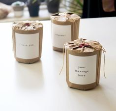 three small jars are wrapped in brown paper and tied with twine on the table