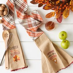 napkins and spoons are laid out on a table with apples, nuts and other items