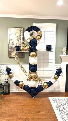 an anchor made out of beads and pearls on a wooden floor in a living room