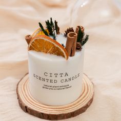 a candle with cinnamons and an orange slice