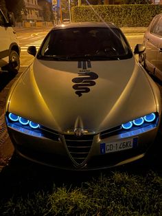 a silver car parked on the side of a road next to a white car with blue lights