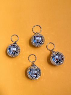 three pieces of disco ball sitting on top of a yellow surface