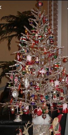 a silver christmas tree with ornaments on it