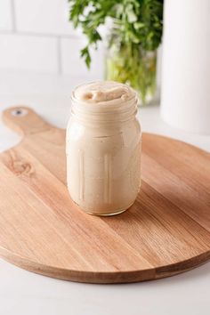 a jar of cream sitting on top of a wooden cutting board