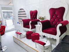 two red chairs sitting next to each other on top of a white table in front of a mirror