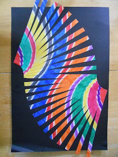 an art project made with colored pencils and paper on a wooden floor, depicting a colorful fan