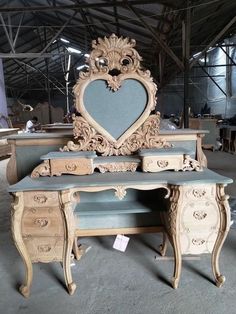 an ornate desk with a heart shaped mirror on top