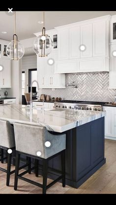 a large kitchen with white cabinets and marble counter tops, an island in the middle