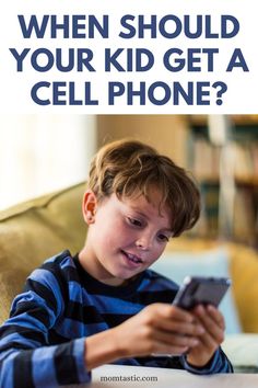 a young boy is looking at his cell phone with the text, when should your kid get a cell phone?