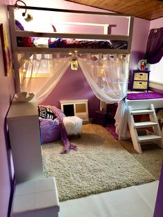 a loft bed with white curtains and purple walls