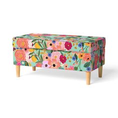 an upholstered chest with flowers painted on it