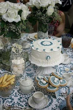 a table topped with lots of white flowers and cakes