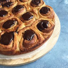 a chocolate covered pastry sitting on top of a wooden cutting board