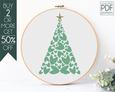 a cross - stitch christmas tree is shown in green and white, with the text buy 2 or more get 50 % off